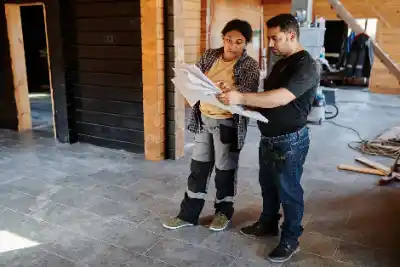 Two workers examining blueprints indoors | Charleston Concrete