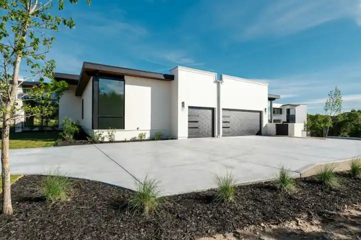 White house with concrete driveway serving two garage doors | Charleston Concrete