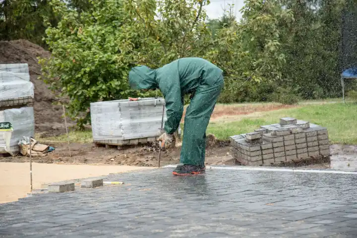 Worker wearing protective gear laying paving | Charleston Concrete